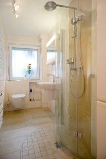 Bad mit weggeklappter ebenerdige Dusche